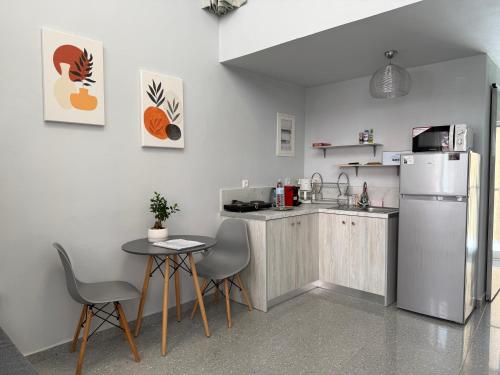 a kitchen with a refrigerator and a table and chairs at Tête à Tête - Loft Apartment in Rhodes Town