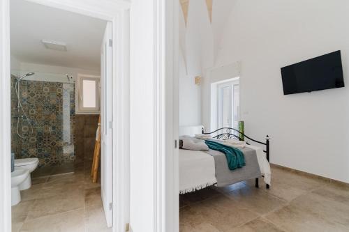 a bathroom with a bed and a toilet and a tv at Dimora storica Jolanda a Uggiano in Uggiano la Chiesa
