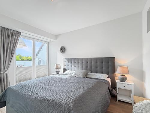 ein weißes Schlafzimmer mit einem großen Bett und einem Fenster in der Unterkunft 3002 - Grömitz in Grömitz