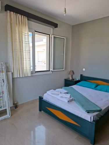 a bedroom with a large bed and a window at Leonidas Apartments in Preveza