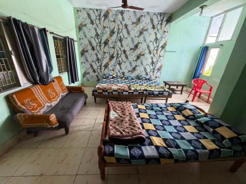 two beds and a couch in a room at Hotel HillView, Junagadh in Junagadh
