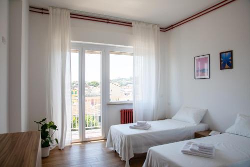 a white room with two beds and a window at MD Beach Home in Roseto degli Abruzzi