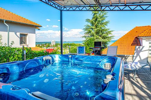 a blue hot tub in a backyard with a view at Apartman 360 in Balatonalmádi