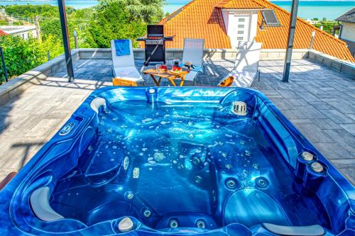 a large blue swimming pool on a patio with a table at Apartman 360 in Balatonalmádi