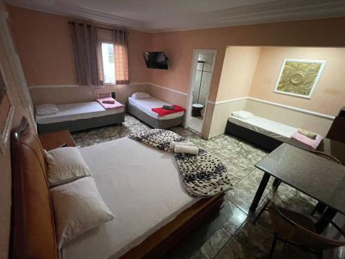 a living room with two beds and a couch at Hotel Vitória de Santos in Santos
