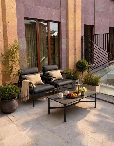 a patio with chairs and a coffee table on a building at Yerevan Resident Hotel in Yerevan