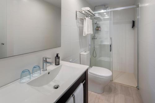 un bagno con lavandino, WC e doccia di Alcanada Golf Hotel a Port d'Alcudia