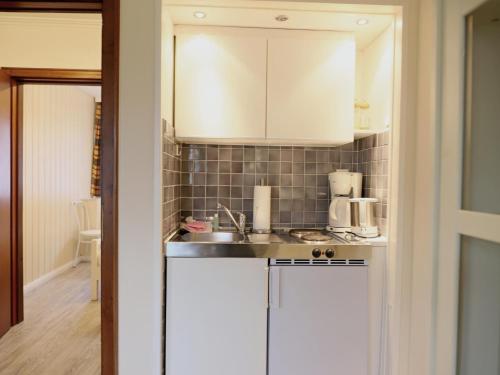 a kitchen with white cabinets and a sink at Fischerweg-39-Whg-2-Amrum in Westerland