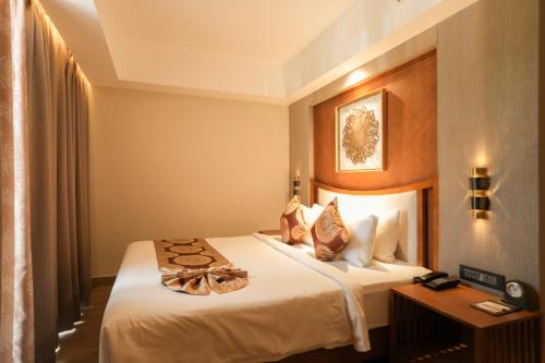 a hotel room with two beds and a table at Raj Regent Manarcadu in Kanjirapalli