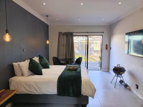 a bedroom with a bed with a table and a chair at Unit 8 Dinas Accommodation Oranjemund in Oranjemund