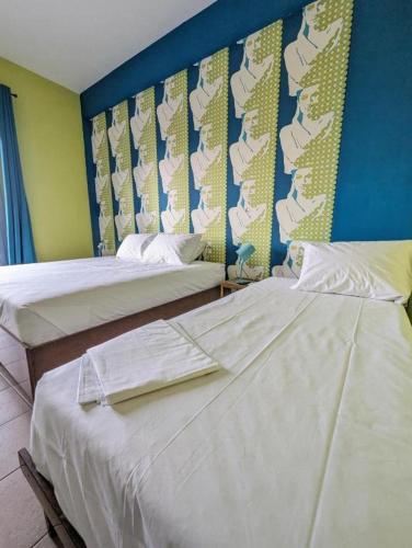 two beds sitting next to each other in a room at Okeania Seafront Rooms in Kamena Vourla in Kamena Vourla