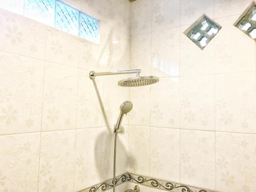 y baño con ducha con cabezal de ducha. en Sapta House en Ubud