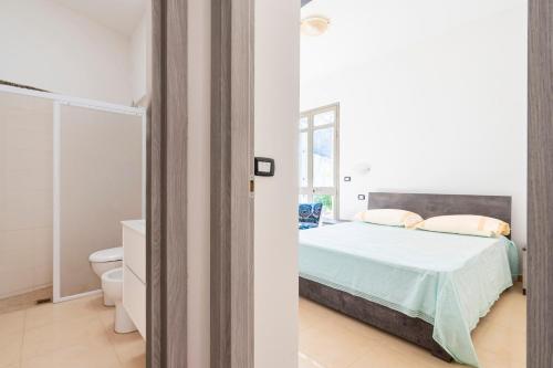 ein weißes Schlafzimmer mit Bett und Toilette in der Unterkunft Db Apartment in Giurdignano
