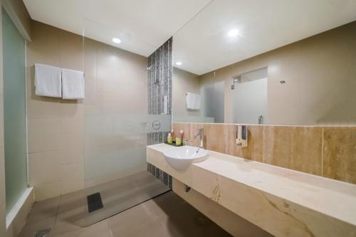 a bathroom with a sink and a mirror at favehotel Pluit Junction in Jakarta