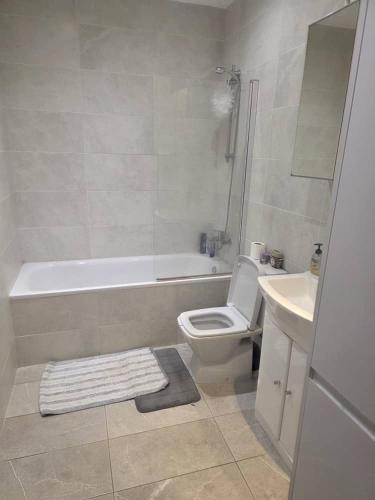 a bathroom with a tub and a toilet and a sink at Holiday Haven in Potters Bar