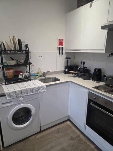 a kitchen with a washing machine and a sink at Holiday Haven in Potters Bar