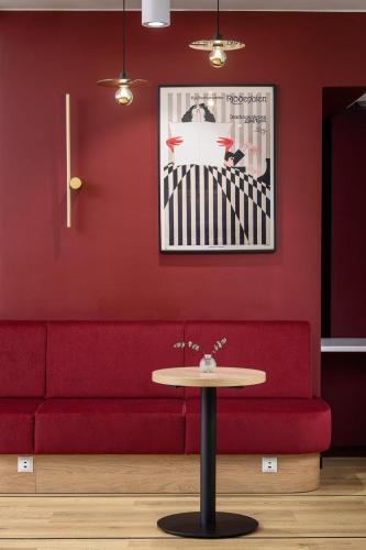 a red couch and a table in a room at B&B HOTEL Kalisz Centrum in Kalisz