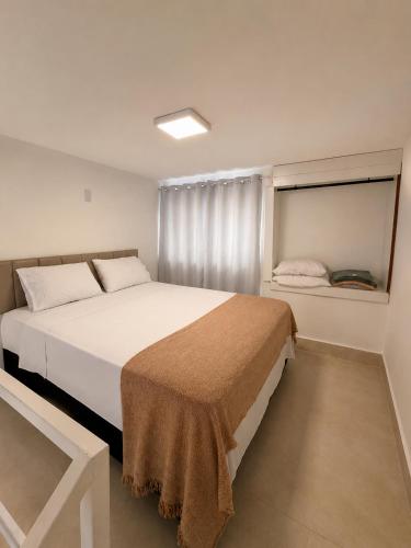 a bedroom with a large white bed and a window at Loft Novo, Duplex, bem ventilado in Aparecida de Goiânia