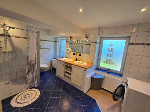 a bathroom with a sink and a shower and a window at Ferienwohnung Küstennah in Großenwiehe