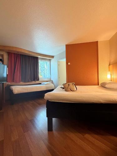 a hotel room with two beds and a window at Ibis Angers Centre Château in Angers