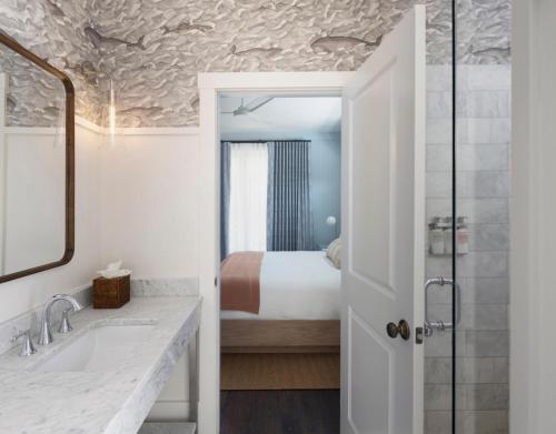 a bathroom with a bed and a sink and a mirror at Hidden Pond Resort in Kennebunkport