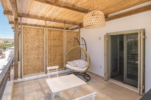 a room with a rattan chair and a table at Arco Solium Suites in Adamantas