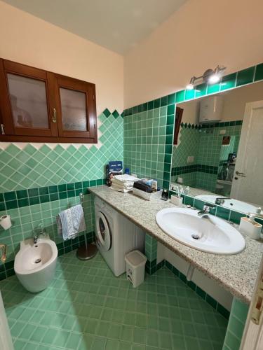 a green bathroom with a sink and a washing machine at Benni Surf House in San Pasquale