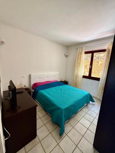 a bedroom with a bed and a desk and a television at Benni Surf House in San Pasquale