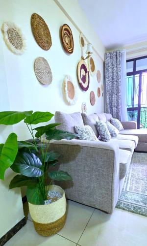 a living room with a couch and a plant at The African Artisan 3BR Apartment in Nairobi