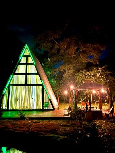 a green lighting up a greenhouse at night at Chalé Paraíso in Nerópolis