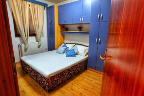 a small bed in a room with blue cabinets at Holiday Home Rocca with pool in Vrgorac