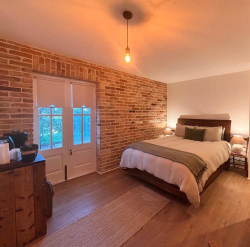a bedroom with a brick wall and a bed at Dromdiah Lodge in Killeagh