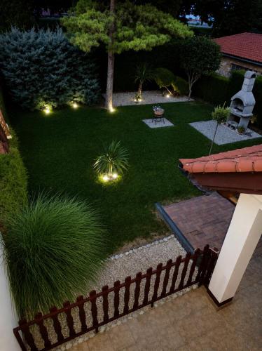 a garden with lights in the grass at night at Era Apartmanház in Harkány