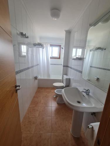 a white bathroom with two toilets and a sink at Apartamentos Telleira in Nigrán