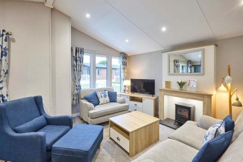 a living room with a couch and a fireplace at The Haven Lodge with Hot Tub in York