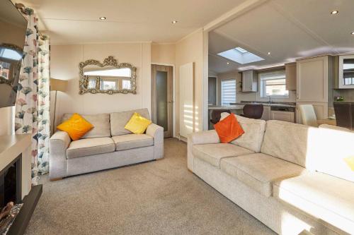 a living room with two couches and a kitchen at Penny Lodge with Hot Tub in Malton