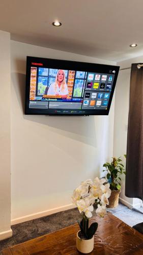 a flat screen tv hanging on a wall at Sleeps 5 Free Parking Fast WiFi Near Hillsborough Easy Access to Sheffield City Centre and Peak District in Hillsborough