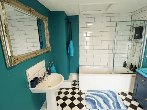 a bathroom with a sink and a tub and a mirror at 35 Wrawby Street in Brigg