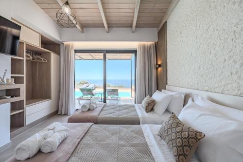 a bedroom with two beds and a view of the ocean at Rodia Luxury Villa in Plakias