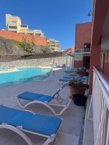 a row of lounge chairs next to a swimming pool at Il Paradiso Esiste in Costa Calma
