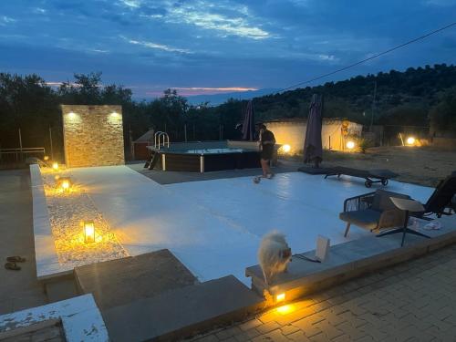a person sitting on a patio at night with a pool table at Olive Hill Guest House in Limenas
