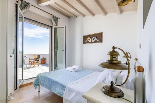 a bedroom with a bed and a view of the ocean at Villa Calma in Patitiri