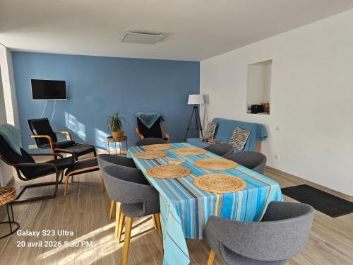a room with a table with chairs and a blue wall at La Longère de Vin'Ay in Vinay