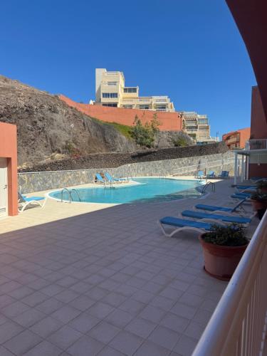 a swimming pool with lounge chairs on a patio at Il Paradiso Esiste in Costa Calma