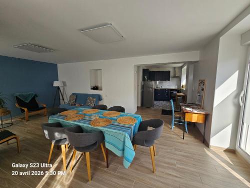 a living room with a blue table and chairs at La Longère de Vin'Ay in Vinay