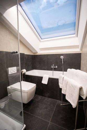 a bathroom with a bath tub and a skylight at Ferienwohnung Daniel in Garmisch-Partenkirchen