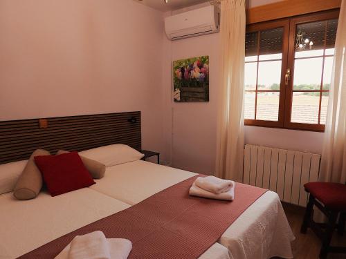 a bedroom with a bed and a window at Casa Rural Arroyo 5 in Mejorada