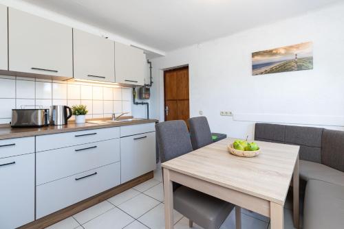 a kitchen with white cabinets and a wooden table at Ferienhaus Neeb in Gammendorf