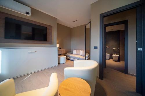 a living room with a television and a table and chairs at Sant'Angela Rooms in Foligno