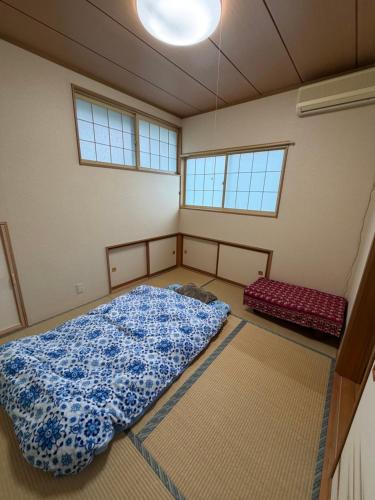 a bedroom with a large bed and two windows at 雅ストリートハウス角館 in Senboku